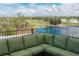 Scenic view of a lush golf course and tranquil lake from a cozy patio seating area at 6919 Dominion Ln, Lakewood Ranch, FL 34202