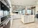 Modern white kitchen boasts sleek stainless steel appliances, center island, and tile floors at 6919 Dominion Ln, Lakewood Ranch, FL 34202