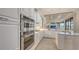 Well-equipped kitchen features stainless steel appliances, white cabinetry, and a view to the living room at 6919 Dominion Ln, Lakewood Ranch, FL 34202