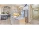 Bright kitchen with an island, stainless steel refrigerator, and view to fireplace area at 6919 Dominion Ln, Lakewood Ranch, FL 34202