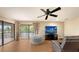 Bright living room featuring hardwood floors, a large television, and sliding glass doors to outdoor space at 6919 Dominion Ln, Lakewood Ranch, FL 34202