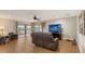 Spacious living room with wood floors, a ceiling fan, and a sliding glass door to the lanai at 6919 Dominion Ln, Lakewood Ranch, FL 34202
