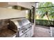 The outdoor kitchen area features a stainless steel grill with dark countertops at 6919 Dominion Ln, Lakewood Ranch, FL 34202