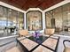 Inviting outdoor patio seating area with views of the home's interior through expansive windows at 6919 Dominion Ln, Lakewood Ranch, FL 34202