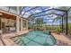 Screened in pool and spa with outdoor kitchen and views of the lush landscaping at 6919 Dominion Ln, Lakewood Ranch, FL 34202