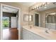 Bathroom with double vanity, large mirror, and easy access to bedroom and balcony at 7039 Strand Cir # 34-201, Bradenton, FL 34203