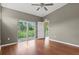 Bright bedroom featuring wood floors, ceiling fan, and a private balcony with views at 7039 Strand Cir # 34-201, Bradenton, FL 34203