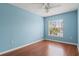 Airy blue bedroom with a large window providing ample natural light and wood floors at 7039 Strand Cir # 34-201, Bradenton, FL 34203