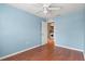 Stylish blue bedroom featuring wood floors, white ceiling fan, and doorway to utility area at 7039 Strand Cir # 34-201, Bradenton, FL 34203