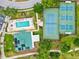 Aerial view of community amenities: pool, hot tub, tennis and pickleball courts, clubhouse with solar panels, and parking at 7039 Strand Cir # 34-201, Bradenton, FL 34203