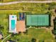 Aerial view of pool and tennis court adjacent to home with manicured lawns and plants at 7039 Strand Cir # 34-201, Bradenton, FL 34203