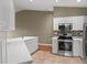 Bright kitchen with white cabinets, stainless steel appliances, tiled floors, and solid surface countertops at 7039 Strand Cir # 34-201, Bradenton, FL 34203