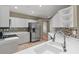 Modern kitchen with white cabinets, a stainless-steel refrigerator, mosaic backsplash, and tiled flooring at 7039 Strand Cir # 34-201, Bradenton, FL 34203