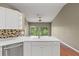 Bright kitchen featuring stainless steel appliances, mosaic backsplash, and a sink with a large window view at 7039 Strand Cir # 34-201, Bradenton, FL 34203