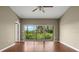Open living room with hardwood floors, a ceiling fan, and sliding glass doors to a balcony at 7039 Strand Cir # 34-201, Bradenton, FL 34203