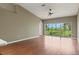 Open living room with vaulted ceilings, wood floors, and sliding glass doors to a balcony overlooking greenery at 7039 Strand Cir # 34-201, Bradenton, FL 34203