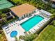 Scenic aerial view of a community pool, hot tub, lounge seating, and lush landscaping at 7039 Strand Cir # 34-201, Bradenton, FL 34203