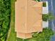Aerial shot of home's roof, adjacent to lush vegetation, manicured lawn and paved driveway at 7039 Strand Cir # 34-201, Bradenton, FL 34203