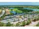 Aerial view of community tennis courts, pool, golf course, lakes, and lush green landscaping at 7315 River Hammock Dr # 101, Bradenton, FL 34212