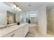 Bright bathroom with double sinks, soaking tub, decorative tile, and a separate glass shower at 7315 River Hammock Dr # 101, Bradenton, FL 34212
