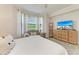 Relaxing bedroom with a large window providing ample natural light, TV, and a comfortable sitting area at 7315 River Hammock Dr # 101, Bradenton, FL 34212