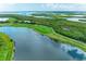 Scenic aerial view of lush golf course with beautiful landscaping, water features, and mangrove-lined islands in the background at 7315 River Hammock Dr # 101, Bradenton, FL 34212