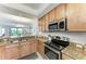Open kitchen showcases granite counters, a stainless steel microwave and range at 7315 River Hammock Dr # 101, Bradenton, FL 34212