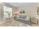 Bright living room with a cozy gray sofa, decorative art, and a view from the bright window at 7315 River Hammock Dr # 101, Bradenton, FL 34212