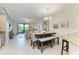 Open-concept living room with a dining area, tile flooring, and sliding doors to the lanai at 7315 River Hammock Dr # 101, Bradenton, FL 34212