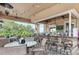 Inviting outdoor bar area with tables, chairs, televisions and views of the lush landscaping at 7315 River Hammock Dr # 101, Bradenton, FL 34212