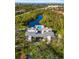 Aerial view shows community pool surrounded by lush greenery and waterfront views at 754 Pine Run Dr # 754, Osprey, FL 34229