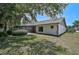 Exterior view of home featuring a lawn and screened-in patio with lush greenery, offering privacy at 7817 Pine Trace Dr # 15, Sarasota, FL 34243