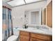 Full bathroom featuring a granite countertop vanity, framed mirror, and shower with patterned curtain at 7817 Pine Trace Dr # 15, Sarasota, FL 34243