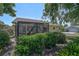 Back of house featuring a screened lanai and mature landscaping, providing a private backyard retreat at 7817 Pine Trace Dr # 15, Sarasota, FL 34243