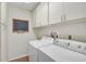 Functional laundry room with washer, dryer, built-in storage, and a chalkboard at 7817 Pine Trace Dr # 15, Sarasota, FL 34243