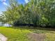This property is on the water with lots of trees for privacy, and a healthy lawn at 8304 Fishhawk Ave, New Port Richey, FL 34653