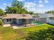 A spacious backyard featuring a screened-in pool and a cozy patio area at 8304 Fishhawk Ave, New Port Richey, FL 34653