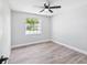 Bedroom featuring light grey walls, hardwood floors and a ceiling fan at 8304 Fishhawk Ave, New Port Richey, FL 34653