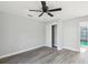 This bedroom features a ceiling fan, gray laminate flooring, and a closet for ample storage space at 8304 Fishhawk Ave, New Port Richey, FL 34653