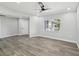 Clean bedroom with modern lighting, neutral walls, wood floors, and a large window that offers natural light at 8304 Fishhawk Ave, New Port Richey, FL 34653