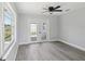 Bedroom featuring wood floors, ceiling fan and access to back yard at 8304 Fishhawk Ave, New Port Richey, FL 34653