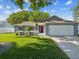 Charming single-story home with a well-manicured lawn and a bright red front door at 8304 Fishhawk Ave, New Port Richey, FL 34653