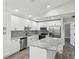Bright kitchen features white cabinets, stainless appliances, granite counters, and a stylish tile backsplash at 8304 Fishhawk Ave, New Port Richey, FL 34653