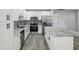 Well-lit kitchen with stainless steel appliances, granite countertops, and sleek white cabinetry at 8304 Fishhawk Ave, New Port Richey, FL 34653