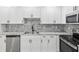 Bright and modern kitchen with stainless appliances, granite countertops, and white cabinetry at 8304 Fishhawk Ave, New Port Richey, FL 34653