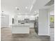 Spacious kitchen featuring white cabinets, an island, stainless steel appliances, and granite countertops at 8304 Fishhawk Ave, New Port Richey, FL 34653