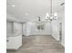 Bright living room with wood floors, neutral walls, modern light fixtures, and natural light from the large window at 8304 Fishhawk Ave, New Port Richey, FL 34653