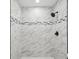Shower with marble tile surround and black shower head at 8304 Fishhawk Ave, New Port Richey, FL 34653