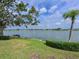 Lush backyard overlooking lake, complemented by landscaping and mature palm tree at 8439 Imperial Cir, Palmetto, FL 34221