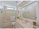 Bathroom with shower, vanity, toilet, framed mirror, and decorative wallpaper at 8439 Imperial Cir, Palmetto, FL 34221